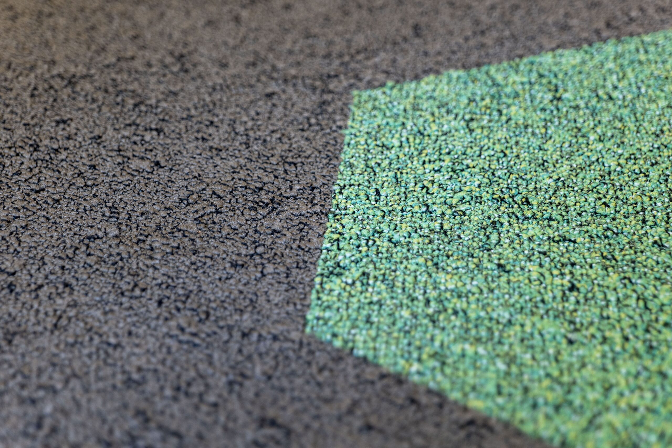 Close-up van groen hexagon accent in donkergrijze tapijtvloer