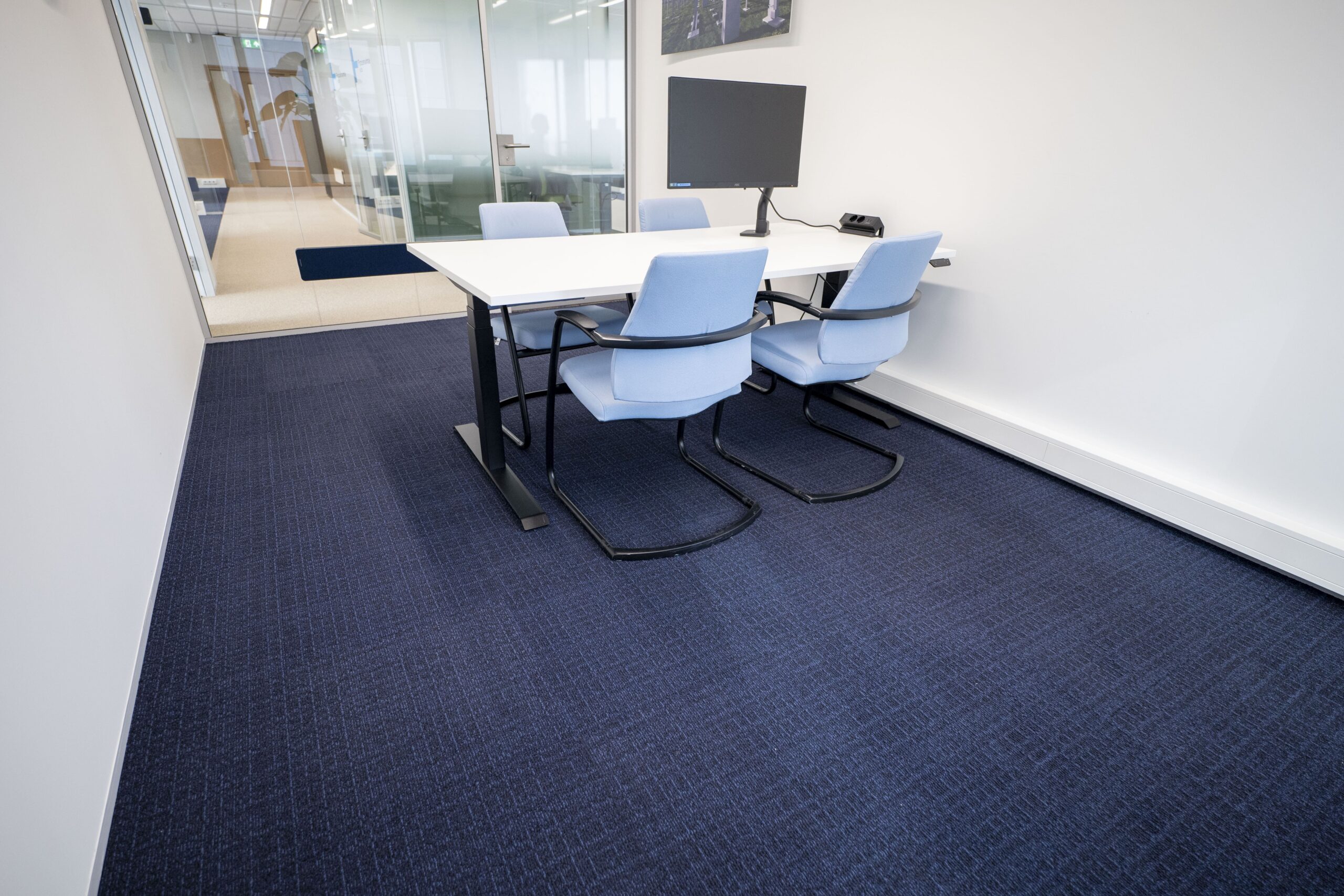 Blauwe refurbished tapijttegels in kleine vergaderruimte bij Witteveen+Bos