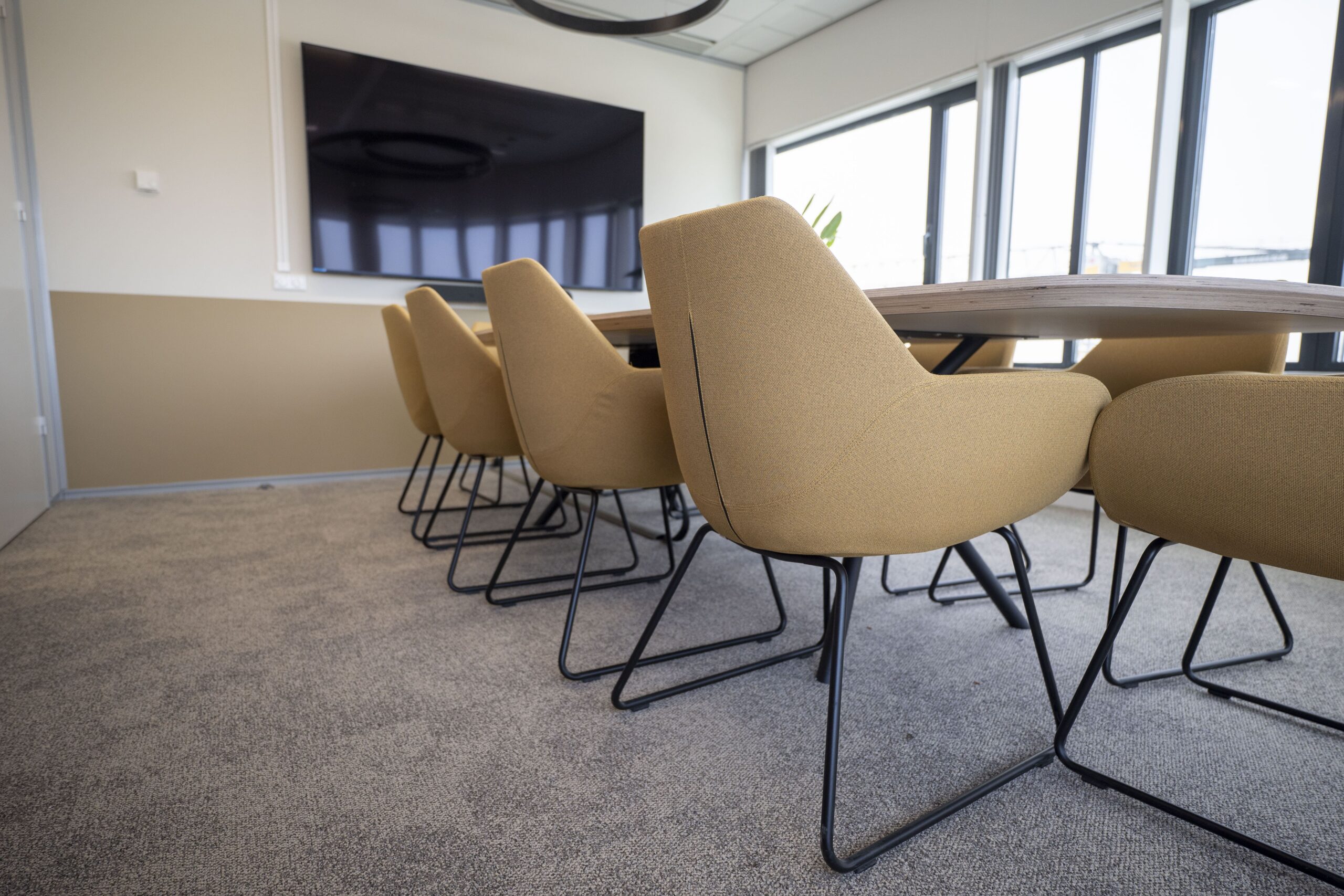 Neutrale circulaire tapijttegels in ruime vergaderkamer bij Witteveen+Bos