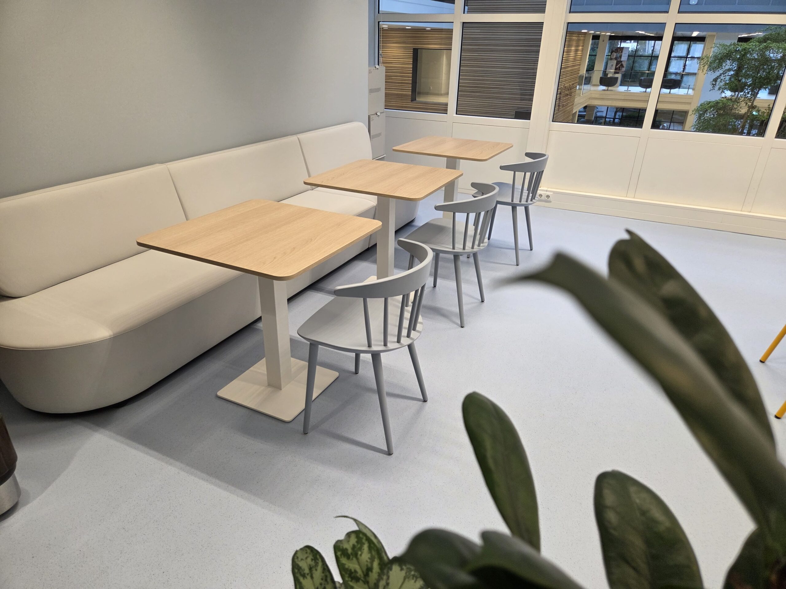 Lichte vloerafwerking in informele zitruimte met bank bij KVK Leeuwarden